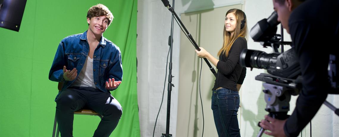 Im Greenscreen-Raum wird ein junger Mann gefilmt